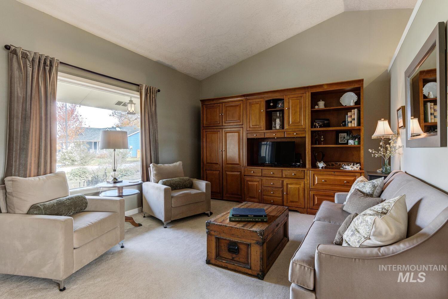 Living room featuring lofted ceiling and light carpet