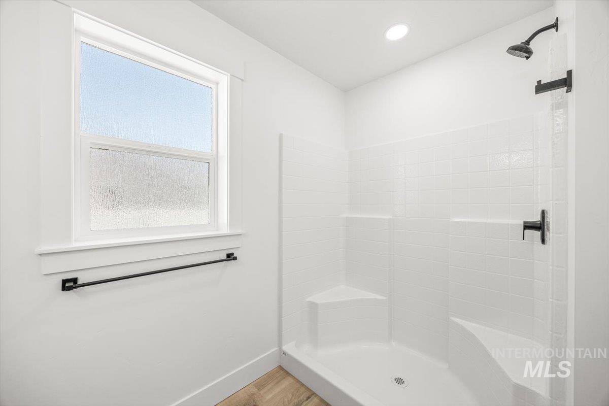 Full bathroom featuring a stall shower, light wood-style flooring, and recessed lighting