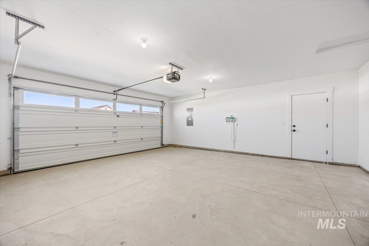 Garage featuring electric panel and a garage door opener