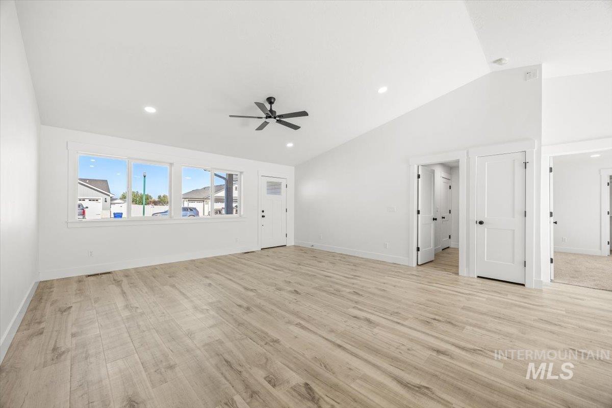 Unfurnished living room featuring vaulted ceiling, light wood-style flooring, recessed lighting, and ceiling fan