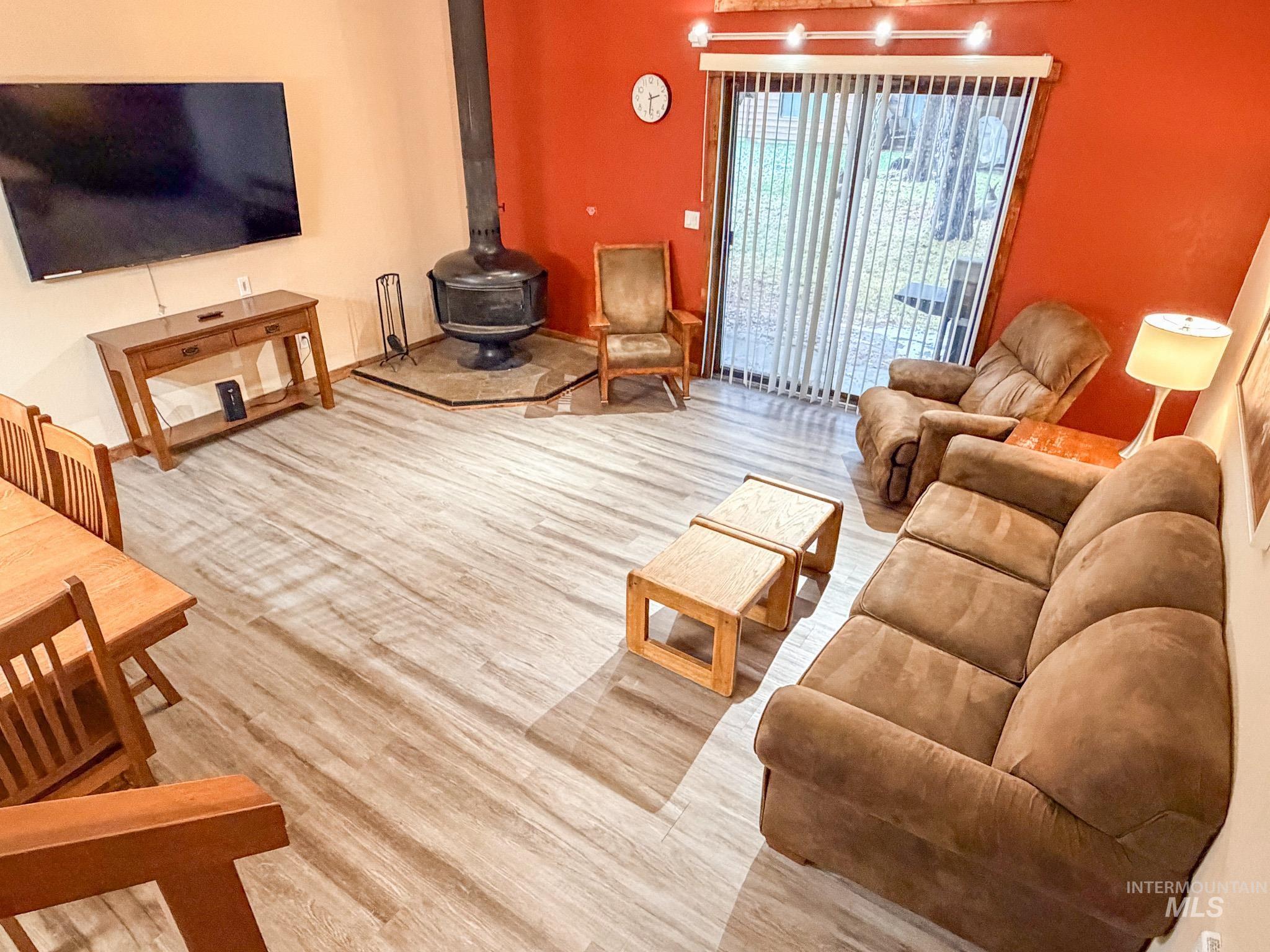 Living area with a wood stove and light wood-style floors