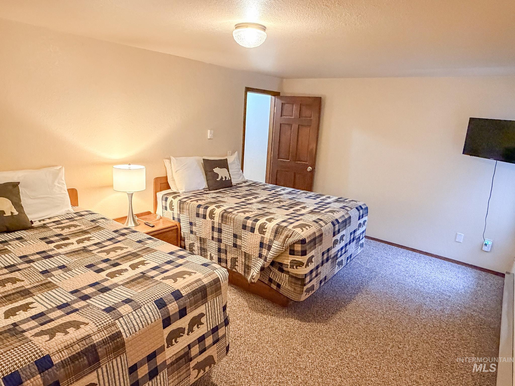 Carpeted bedroom featuring a textured ceiling and baseboards