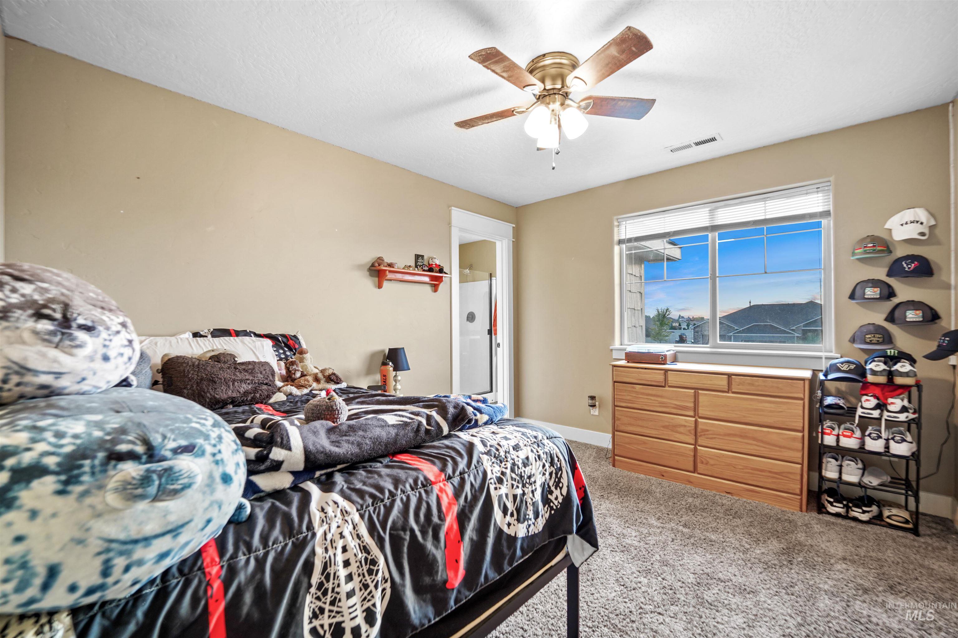 Bedroom featuring light carpet and a ceiling fan
