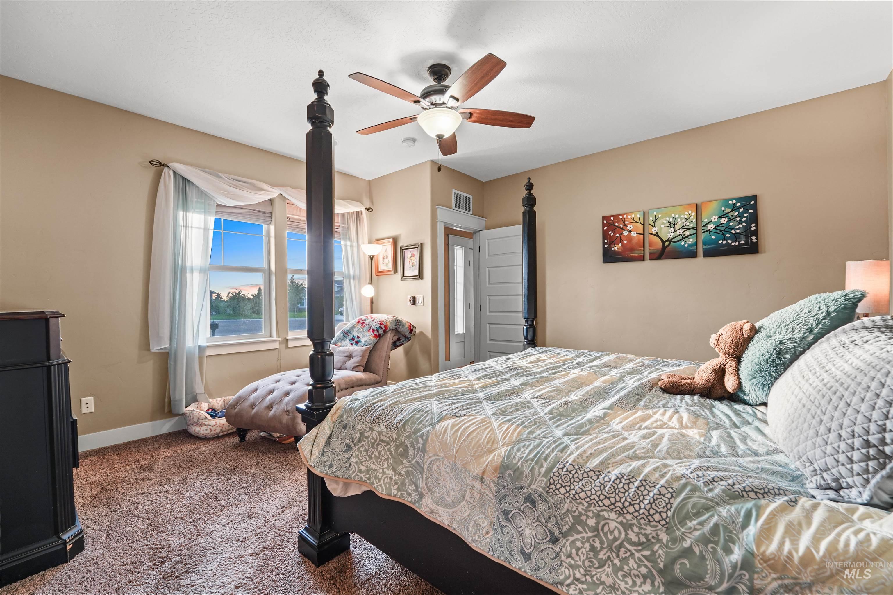 Carpeted bedroom featuring baseboards and a ceiling fan