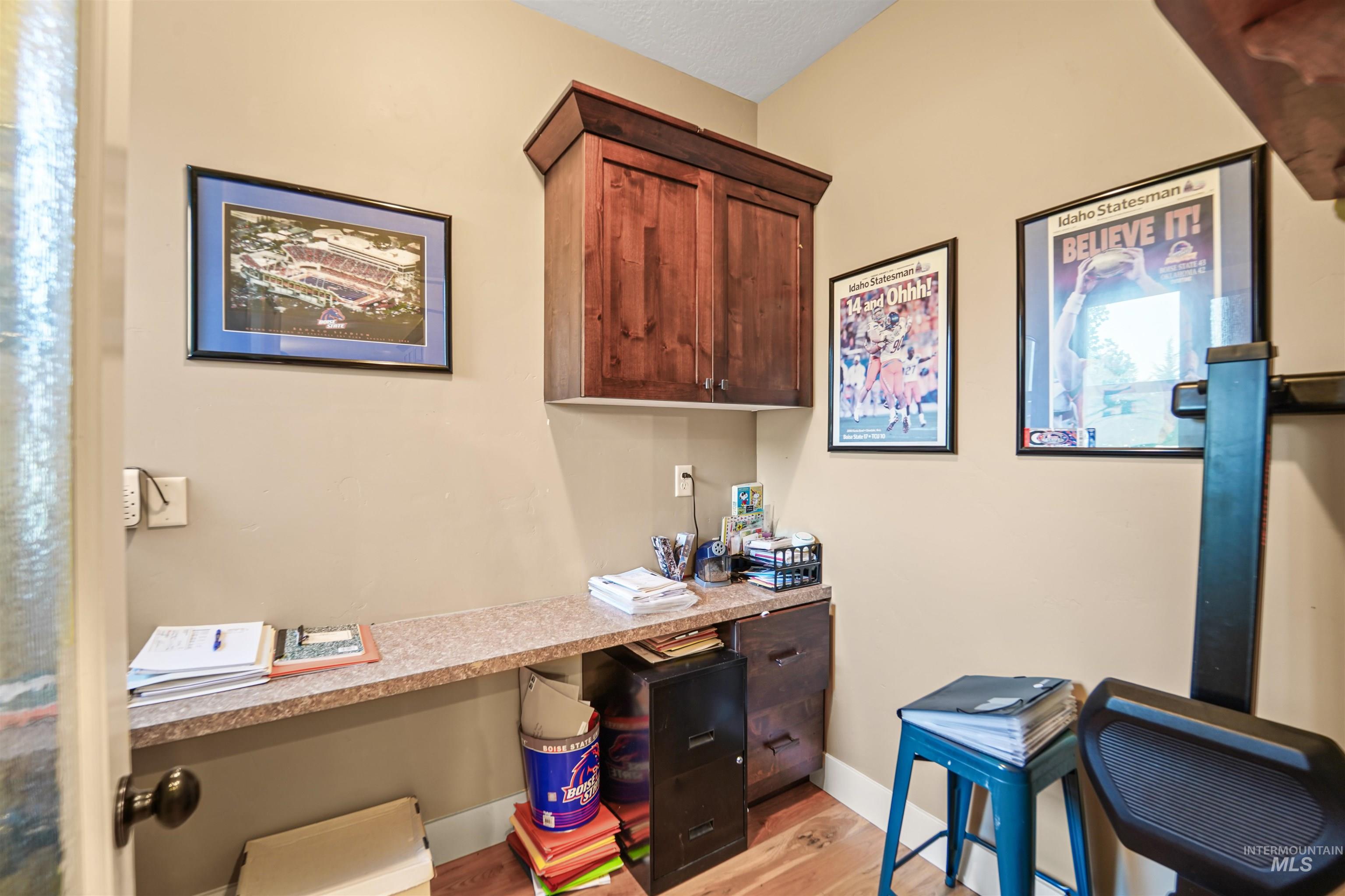 Office with built in study area and light wood-type flooring