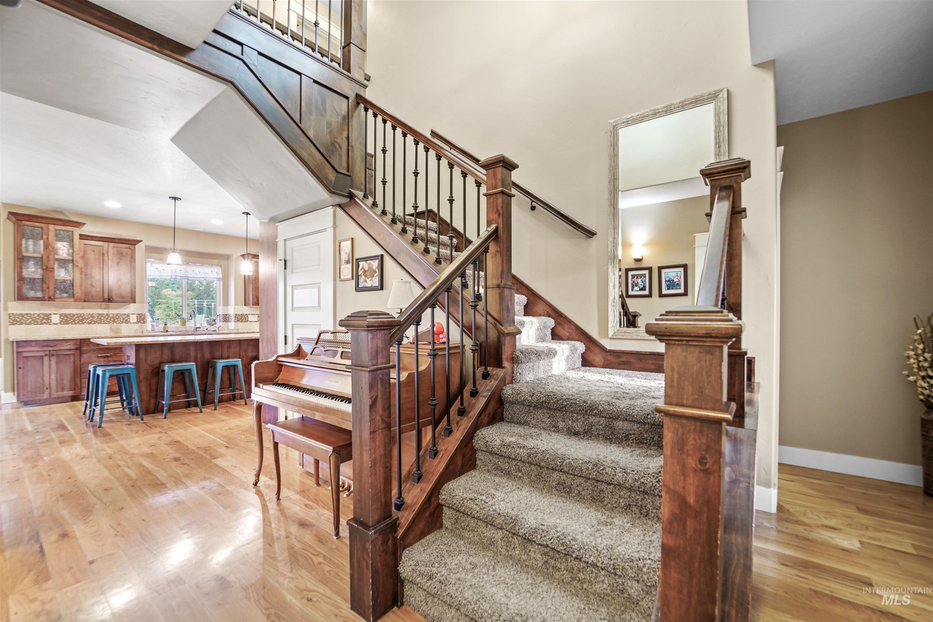 Staircase with wood finished floors and recessed lighting