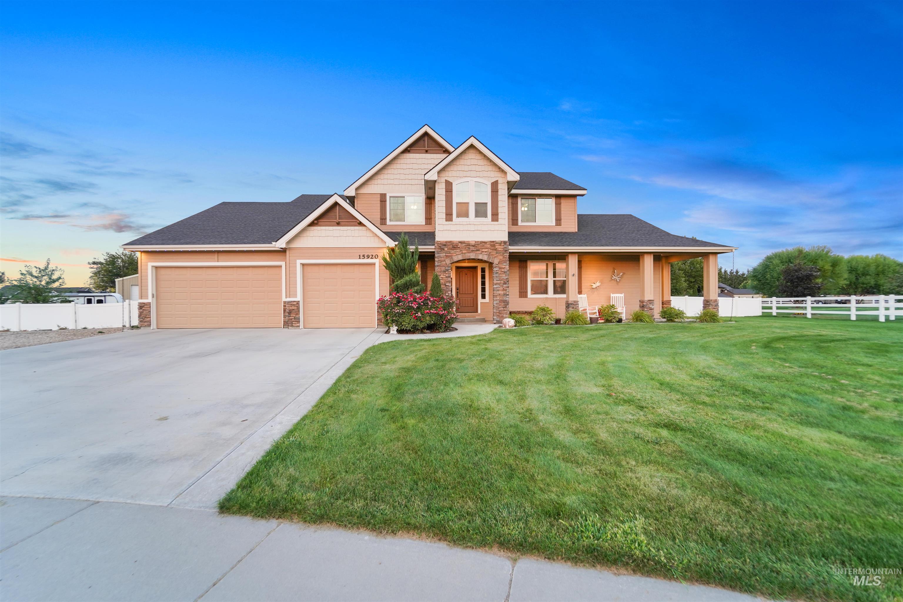 View of front of house featuring stone siding, driveway, a porch, and a garage