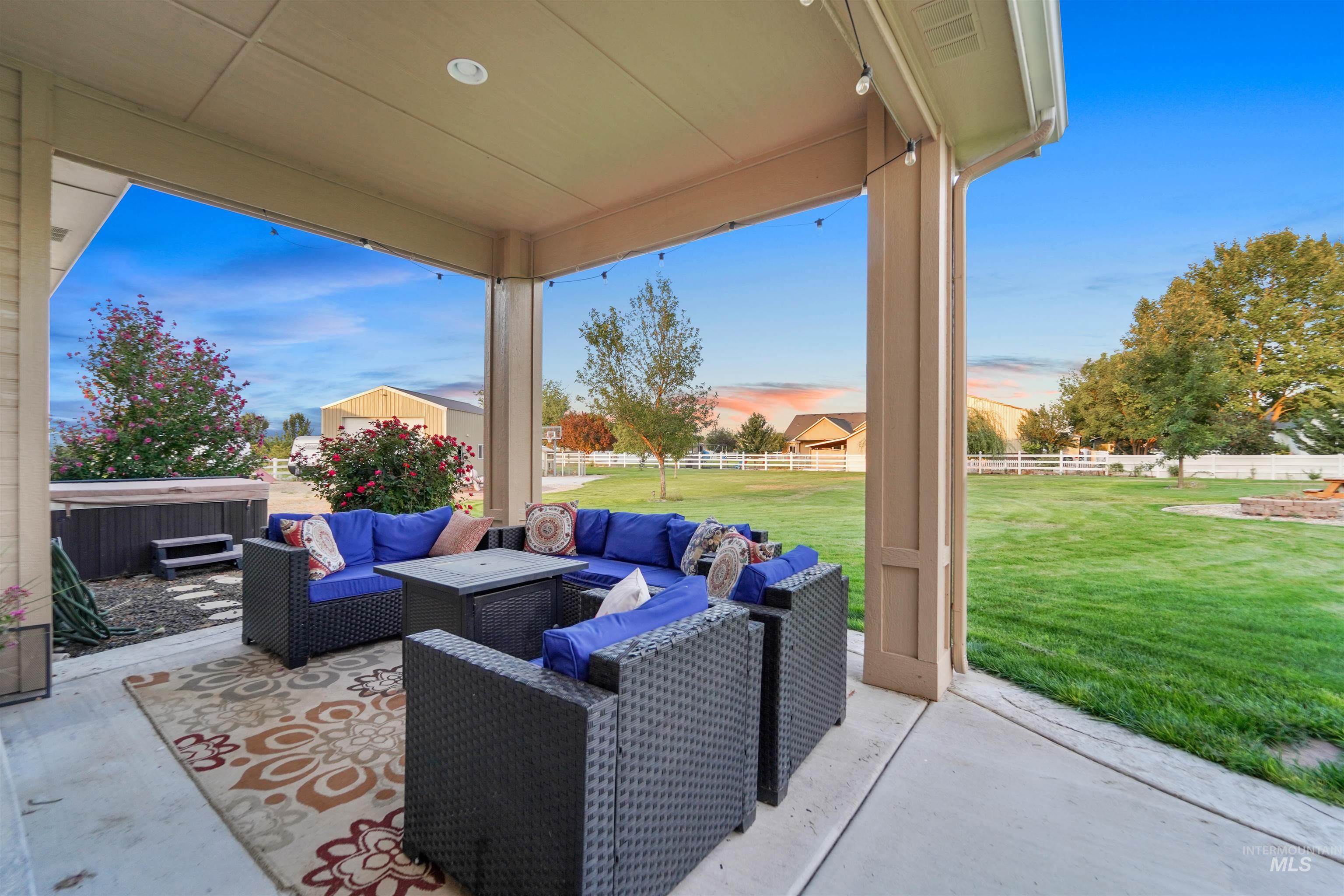 Fenced backyard with a hot tub, an outdoor hangout area, and a patio area