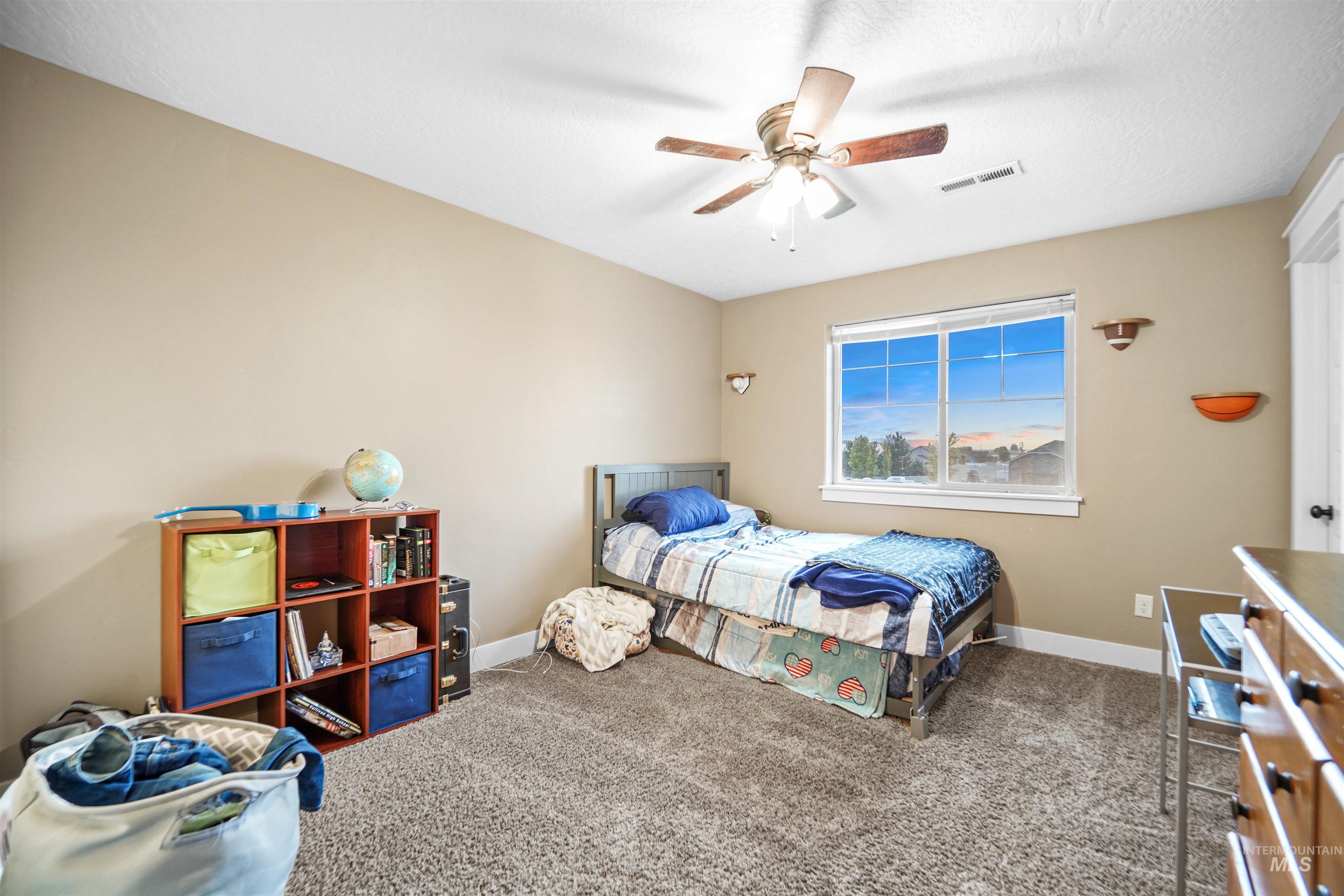Bedroom with carpet floors and a ceiling fan
