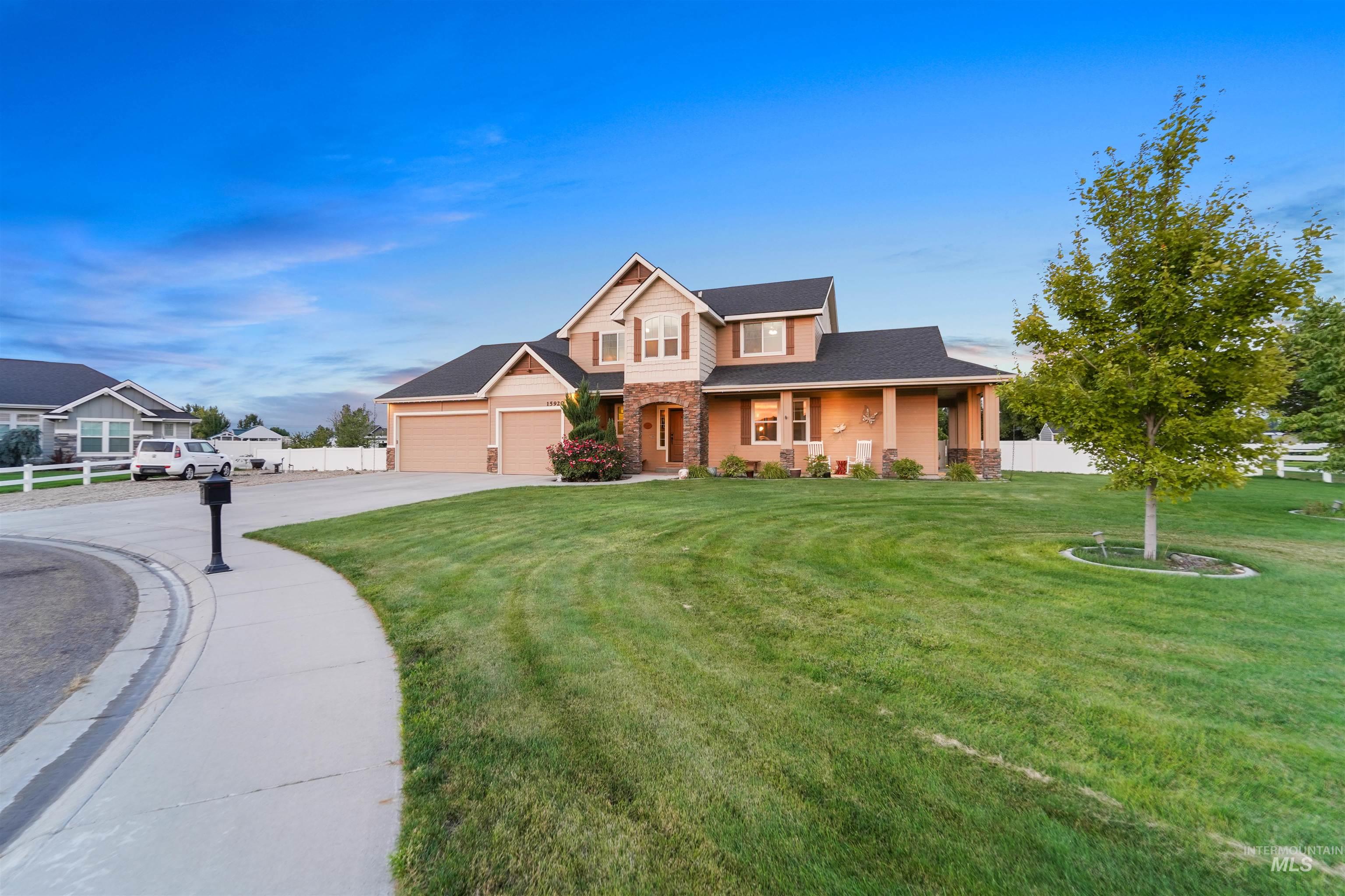 View of front of property with a porch, concrete driveway, and stone siding