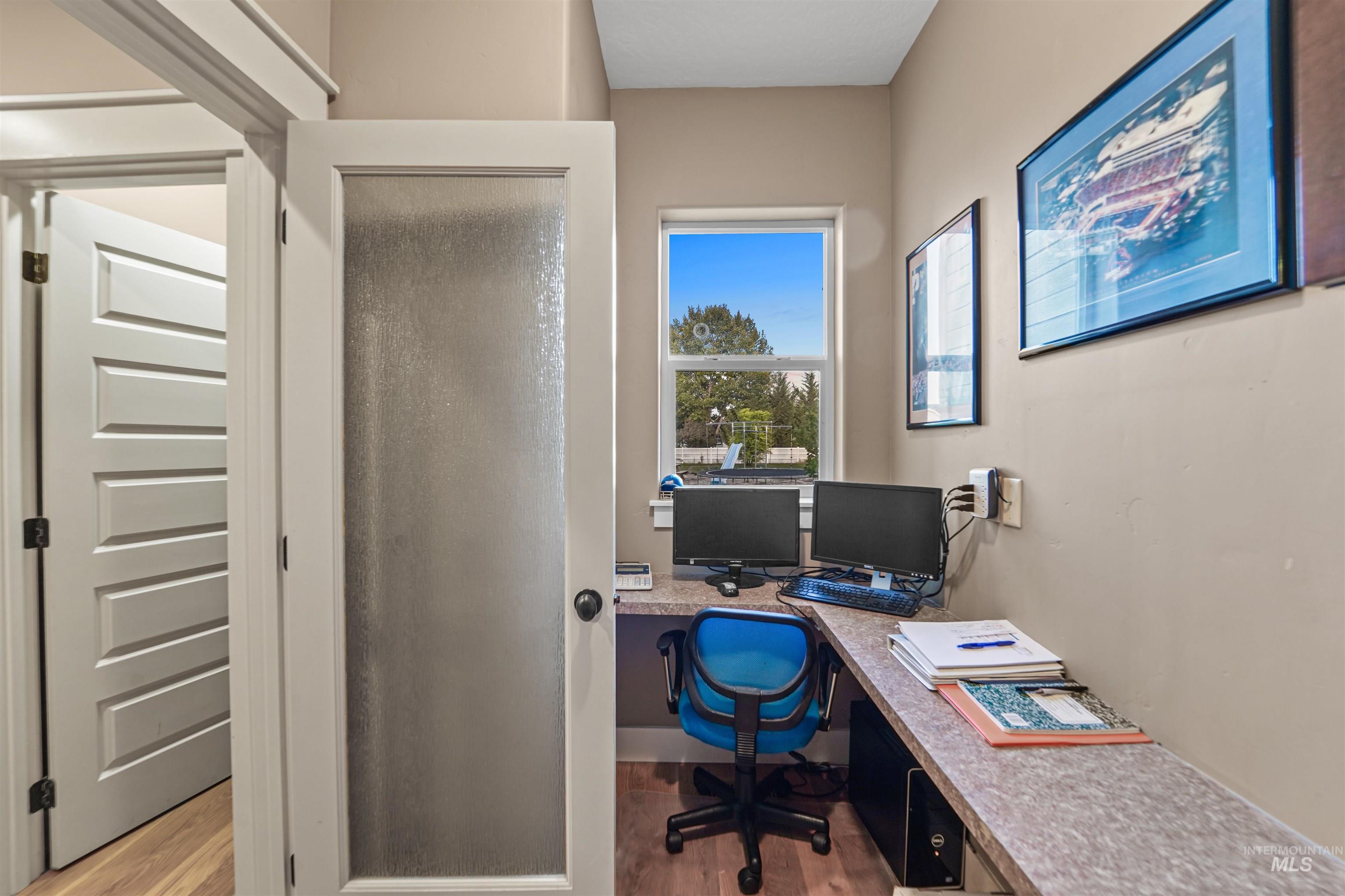 Office space with dark wood finished floors and built in desk