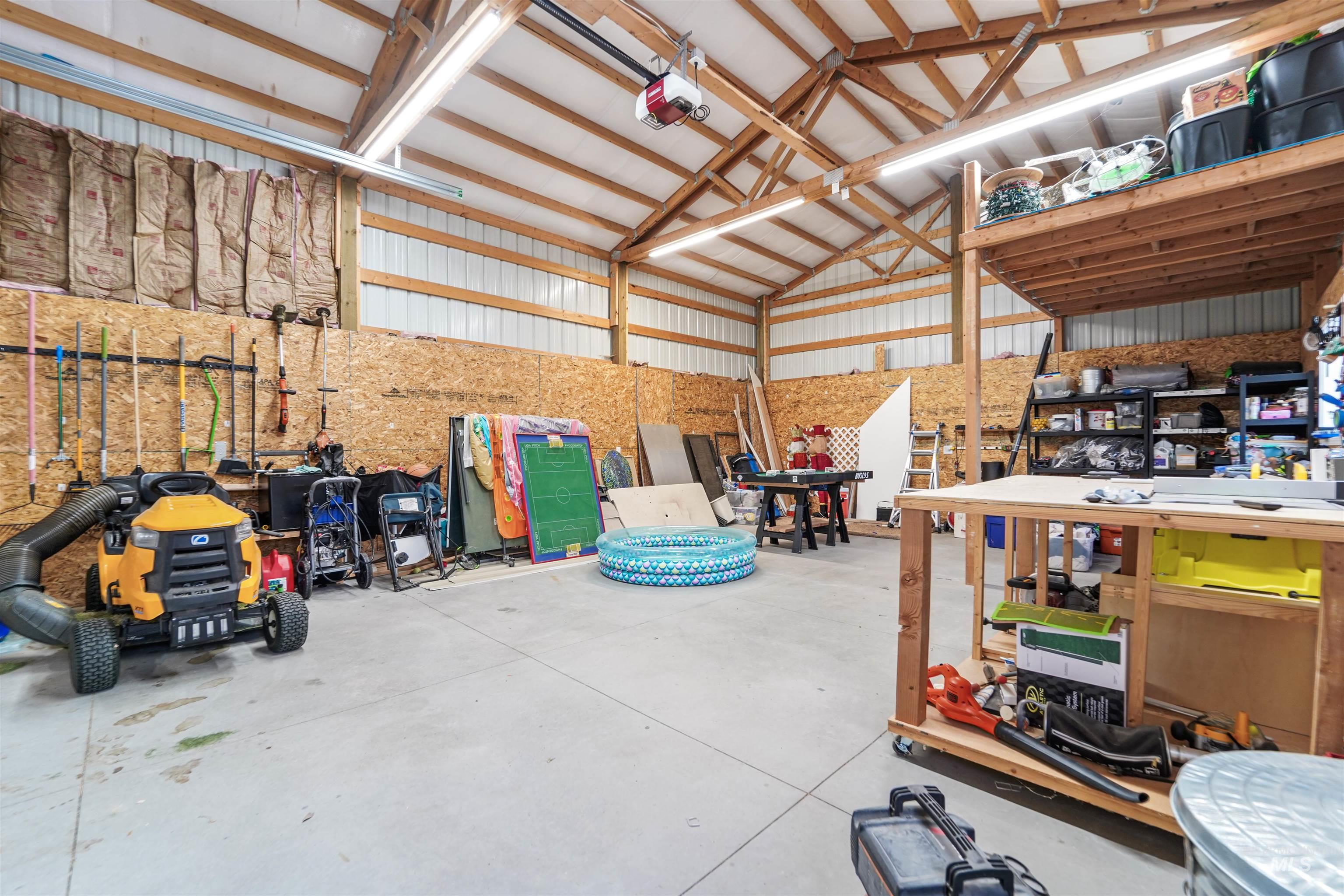 Garage with metal wall, a garage door opener, and a workshop area