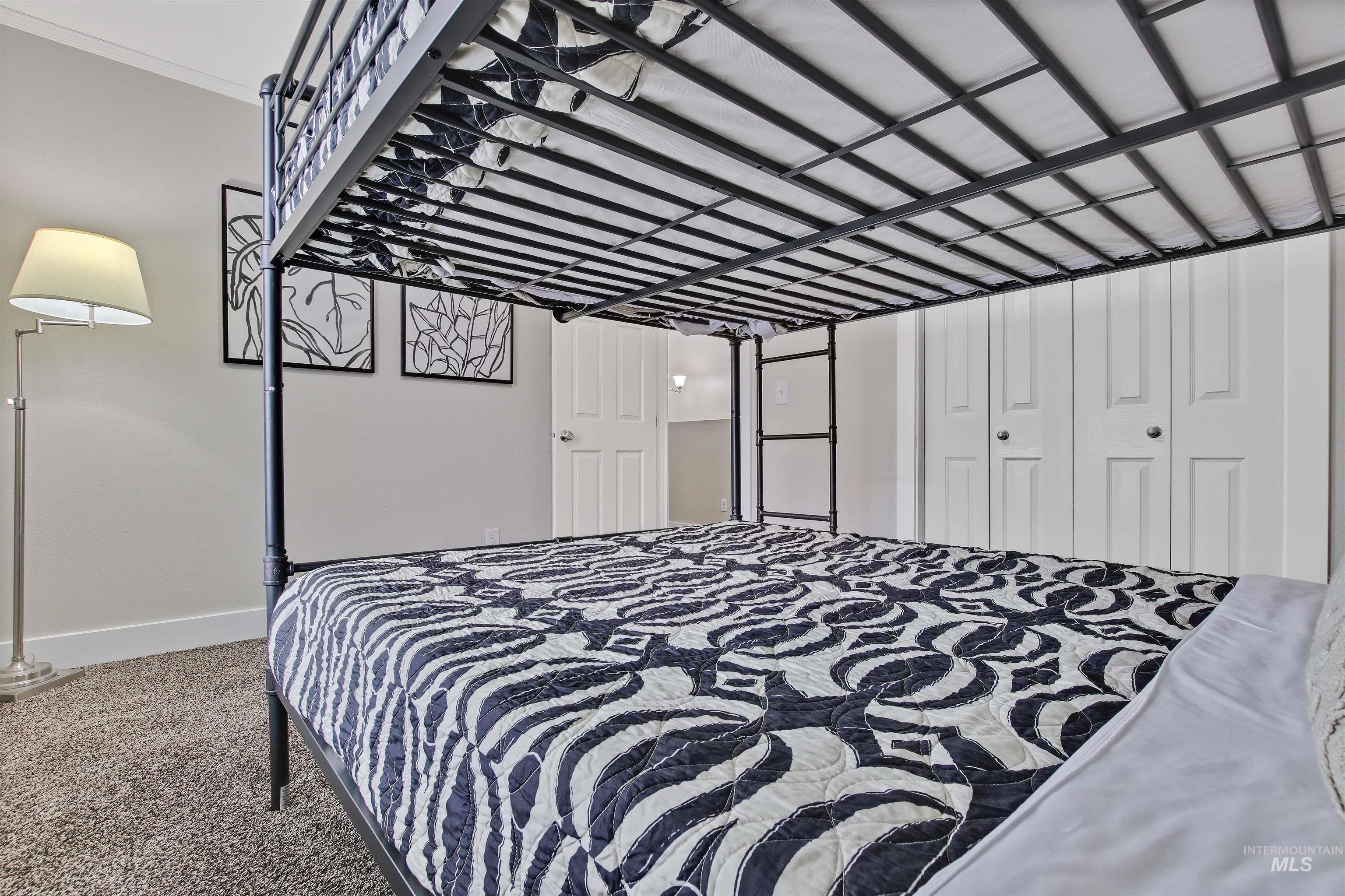 Carpeted bedroom featuring a garage and ornamental molding