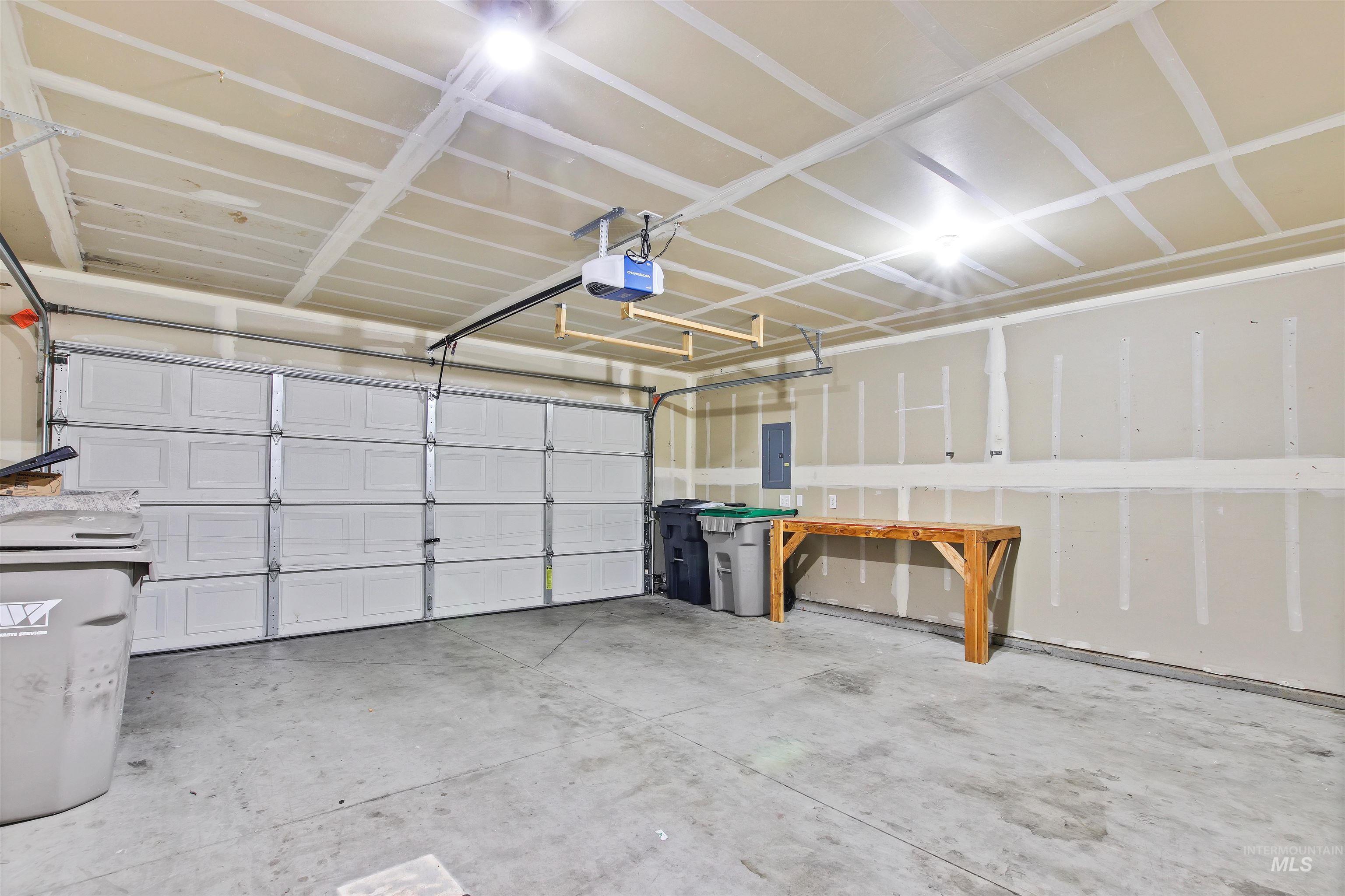 Garage featuring a garage door opener and electric panel