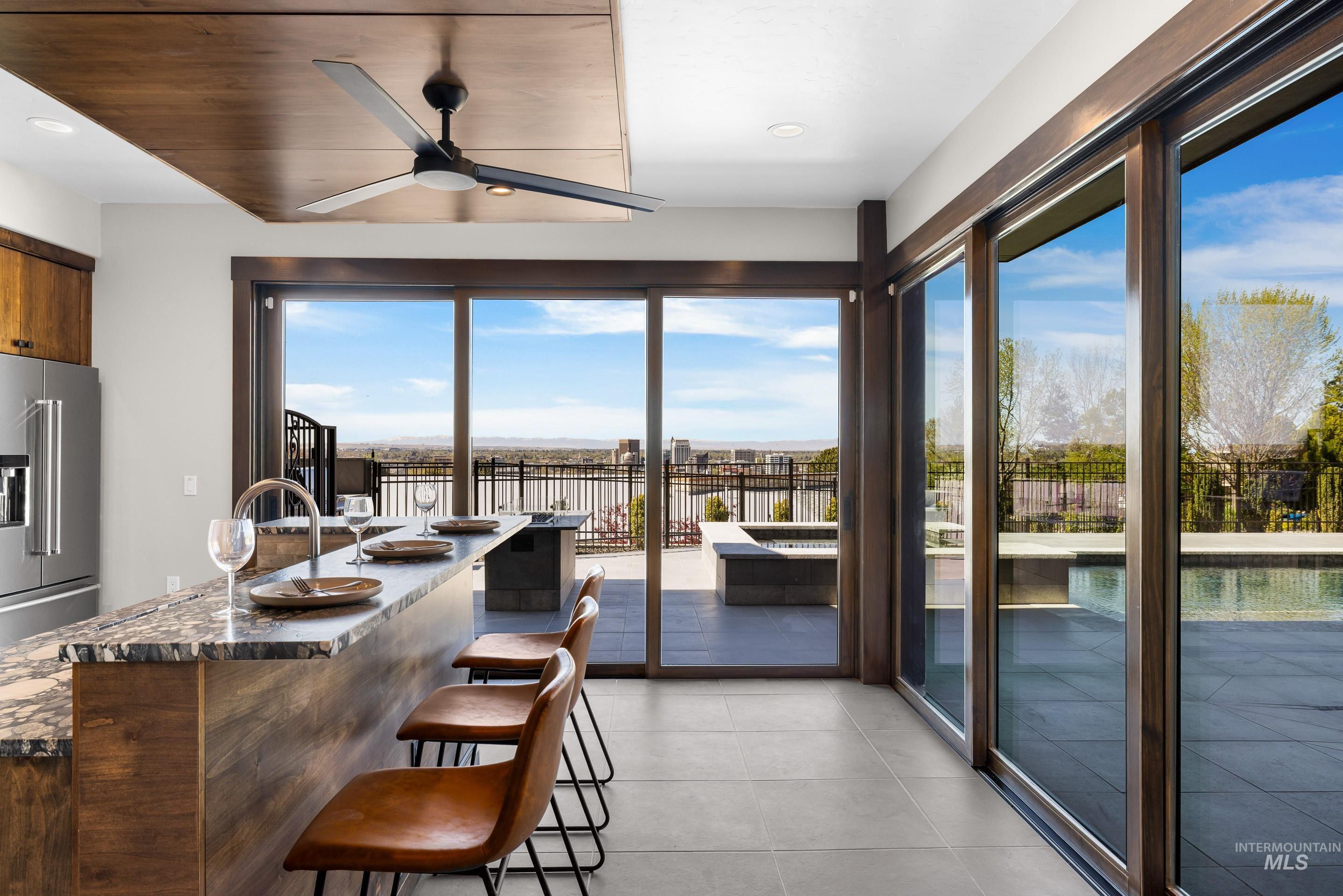 Kitchen island featuring a stone countertop, built-in sink with gooseneck faucet, and integrated breakfast bar
