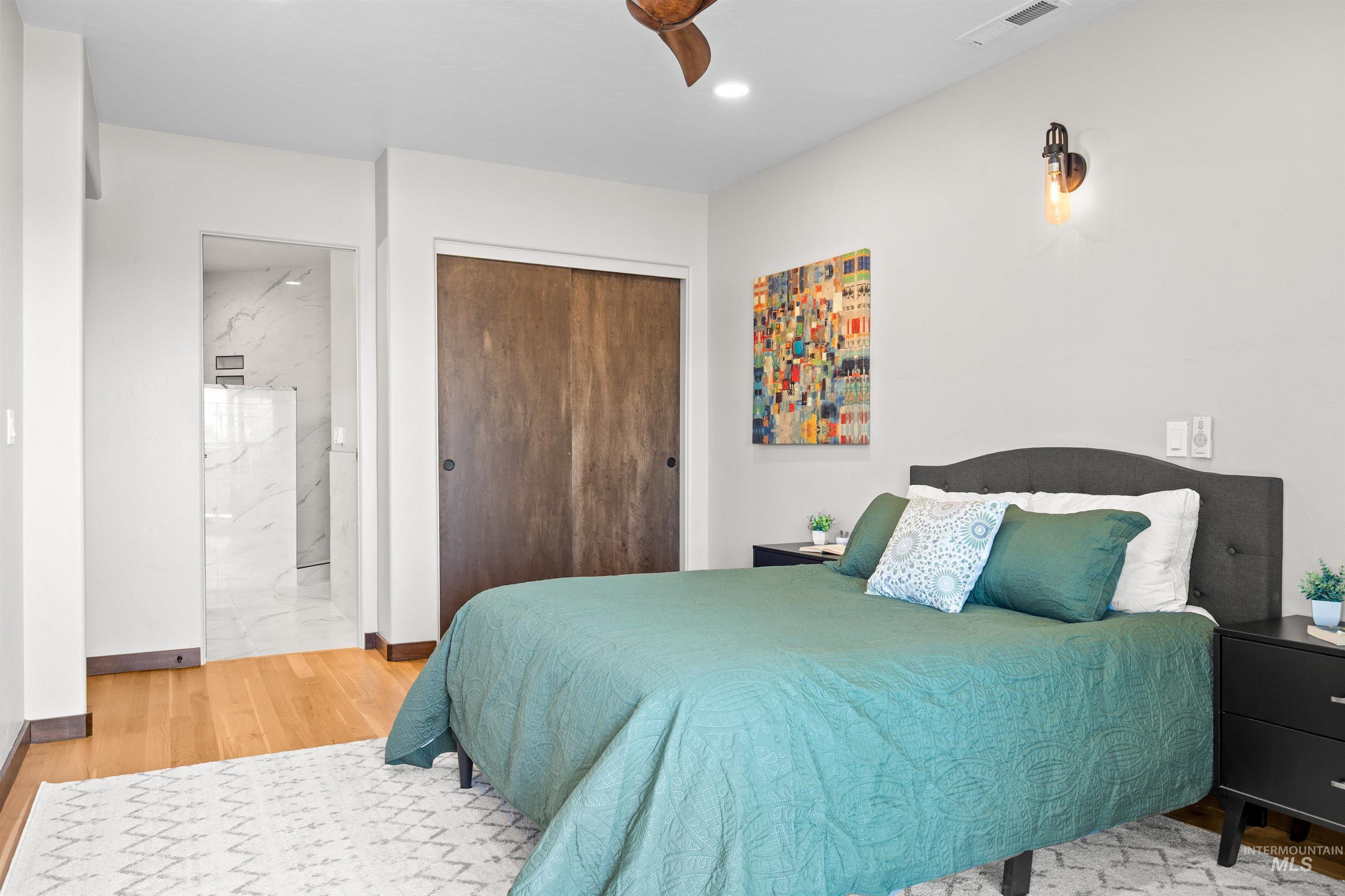 Bedroom featuring natural wood-finish flooring and a ceiling fan
