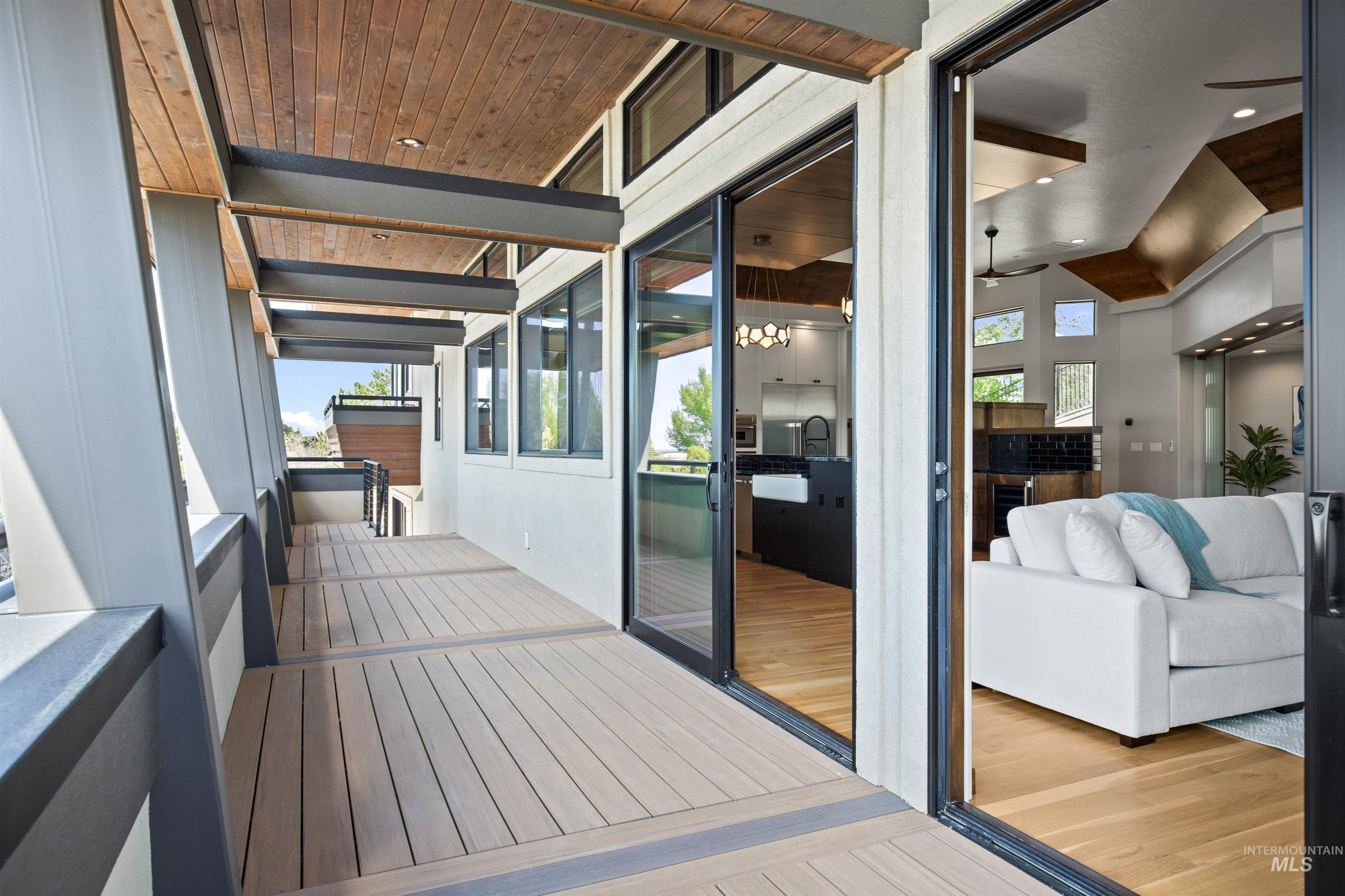Expansive outdoor decking with composite flooring, wood-finish ceiling, and structural beam accents