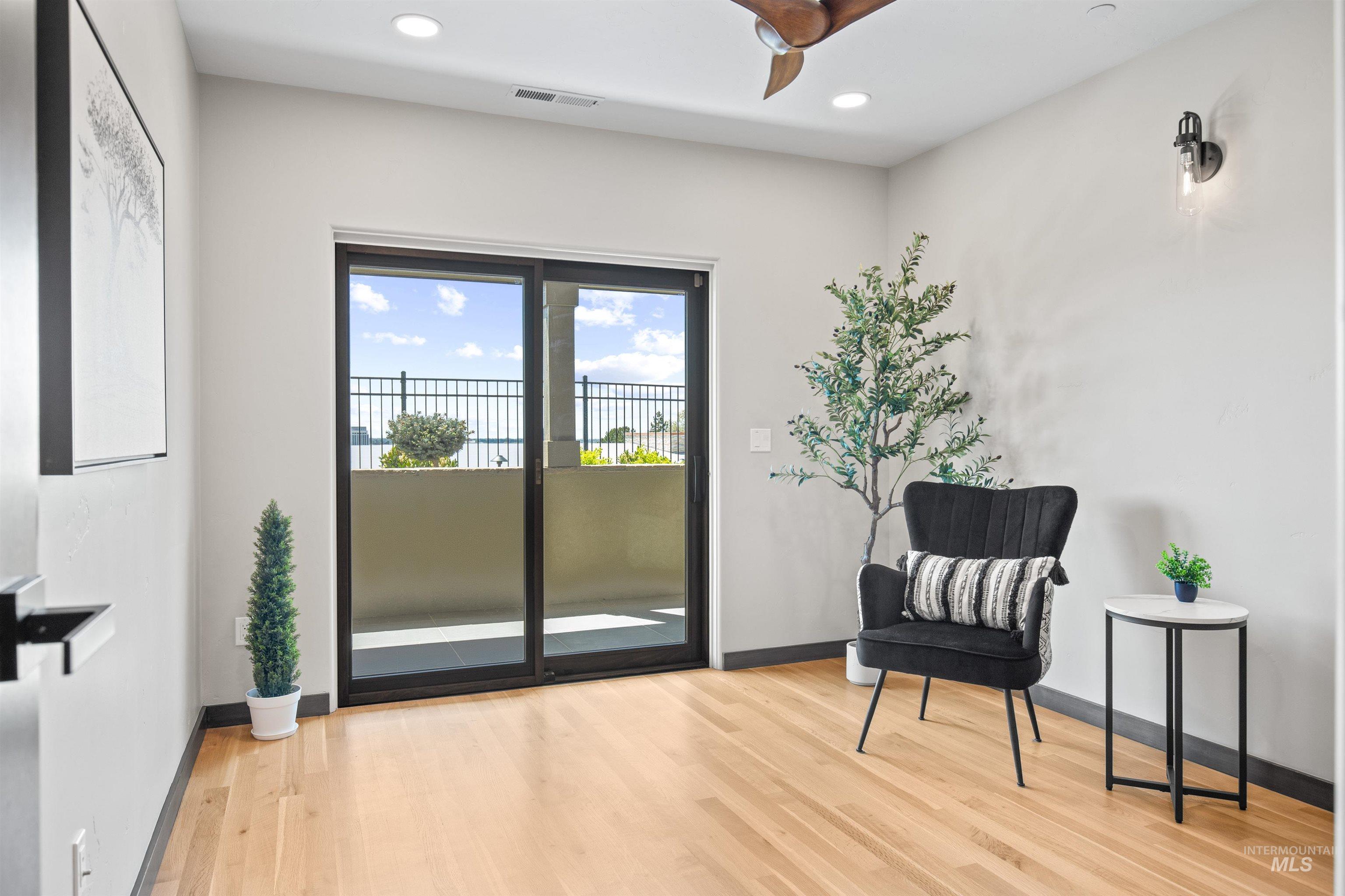 Room featuring wood-finish flooring, recessed lighting, and a ceiling fan