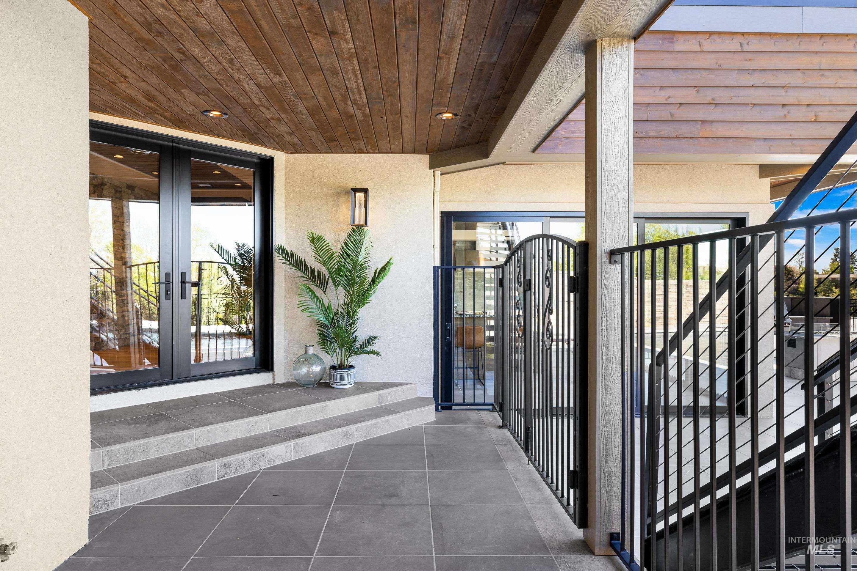 Covered outdoor patio with wood-finish ceiling, recessed lighting, and large format tile flooring