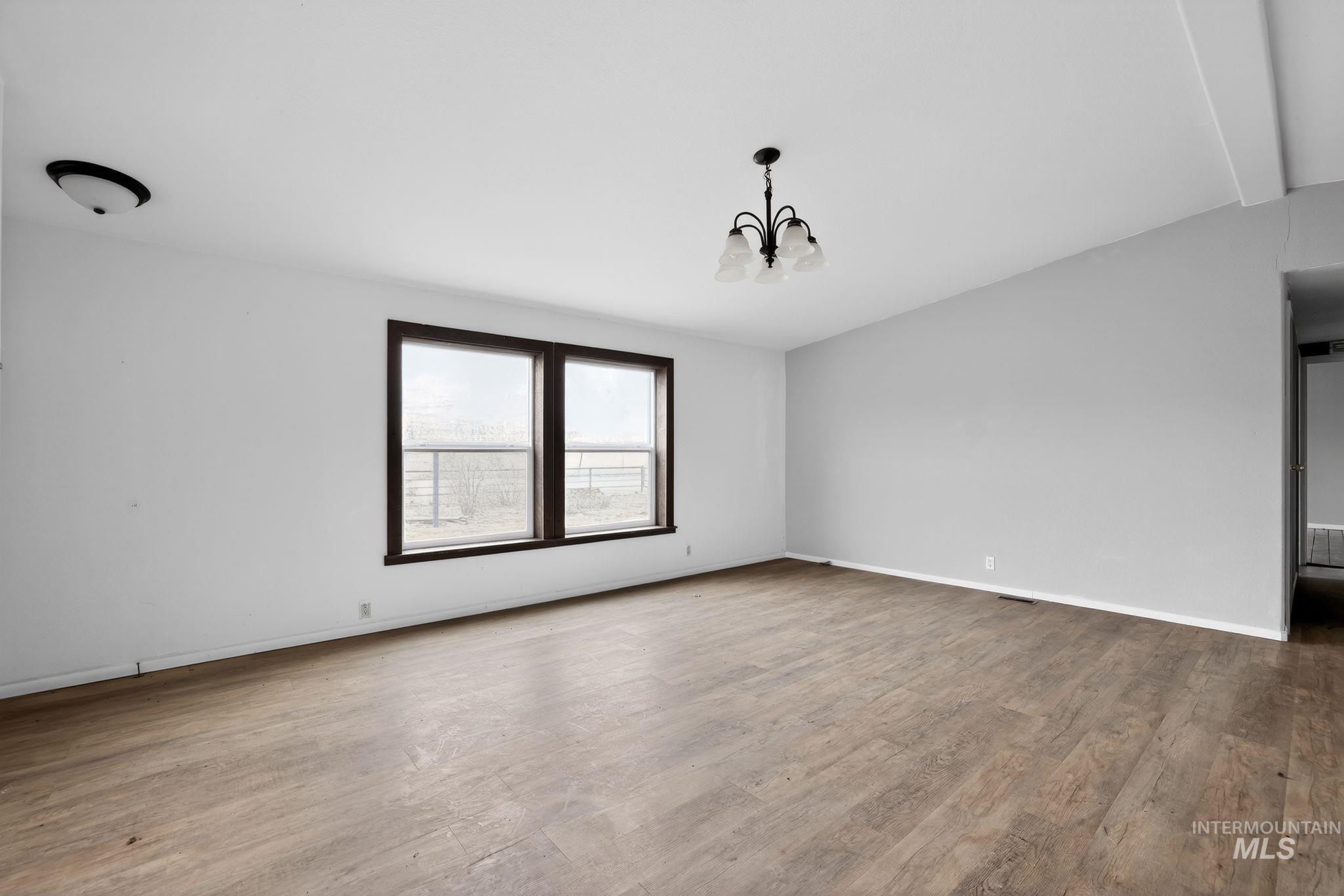 Spare room with a chandelier and light wood-style flooring