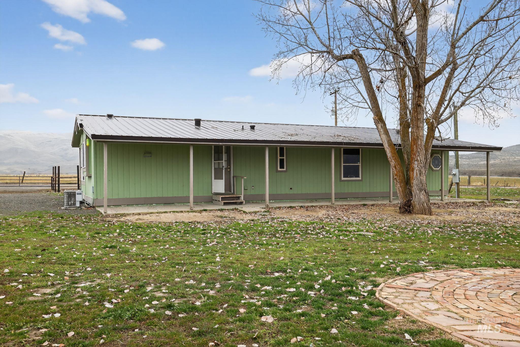 Back of property with entry steps and a metal roof