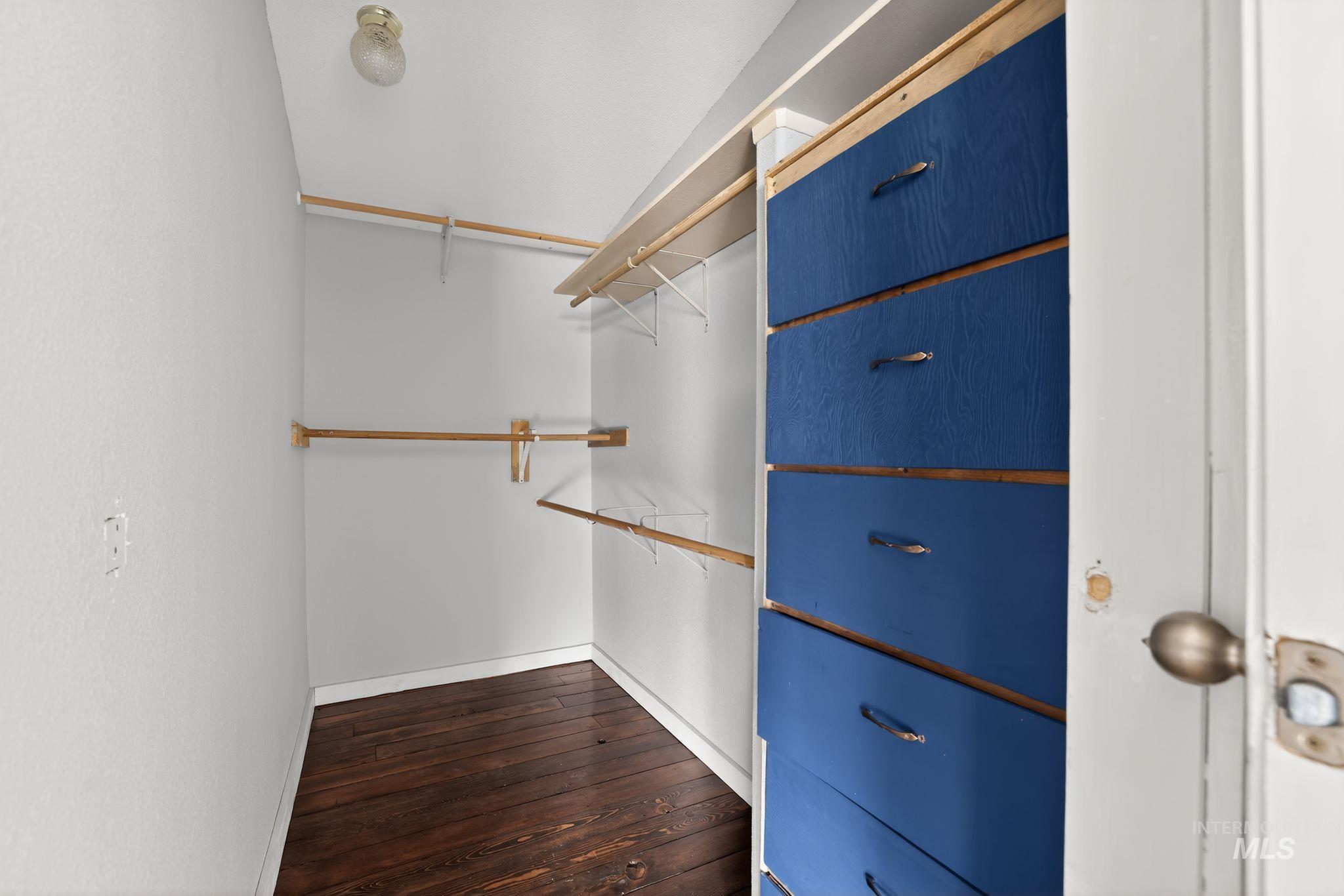 Walk in closet featuring dark wood-type flooring