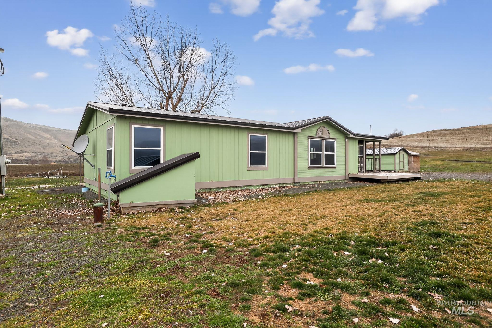 View of side of property featuring a deck with mountain view and a yard