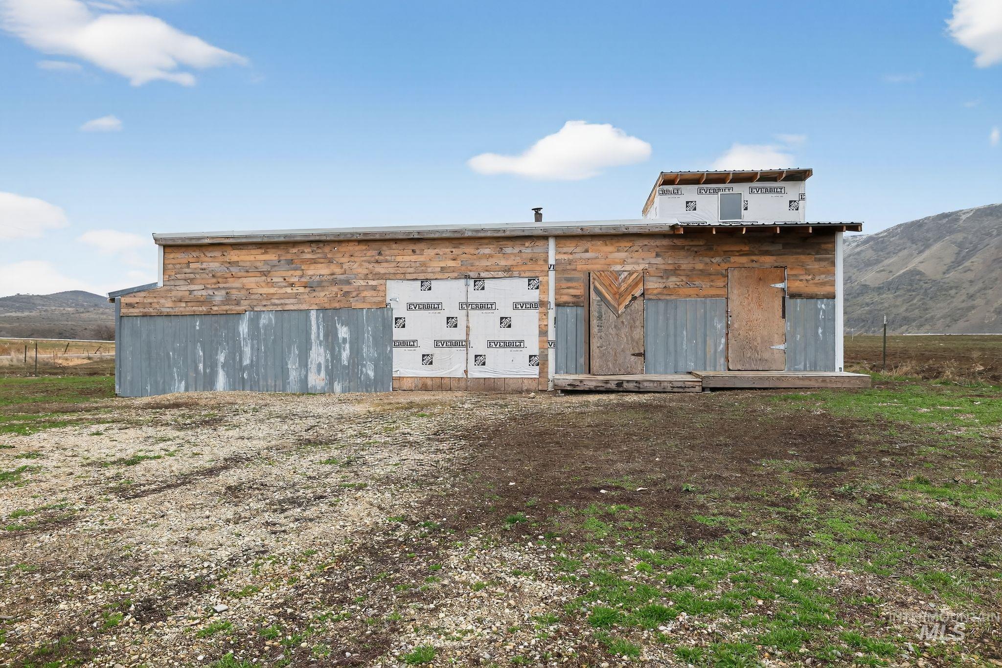 Back of house with a mountain view and an outbuilding