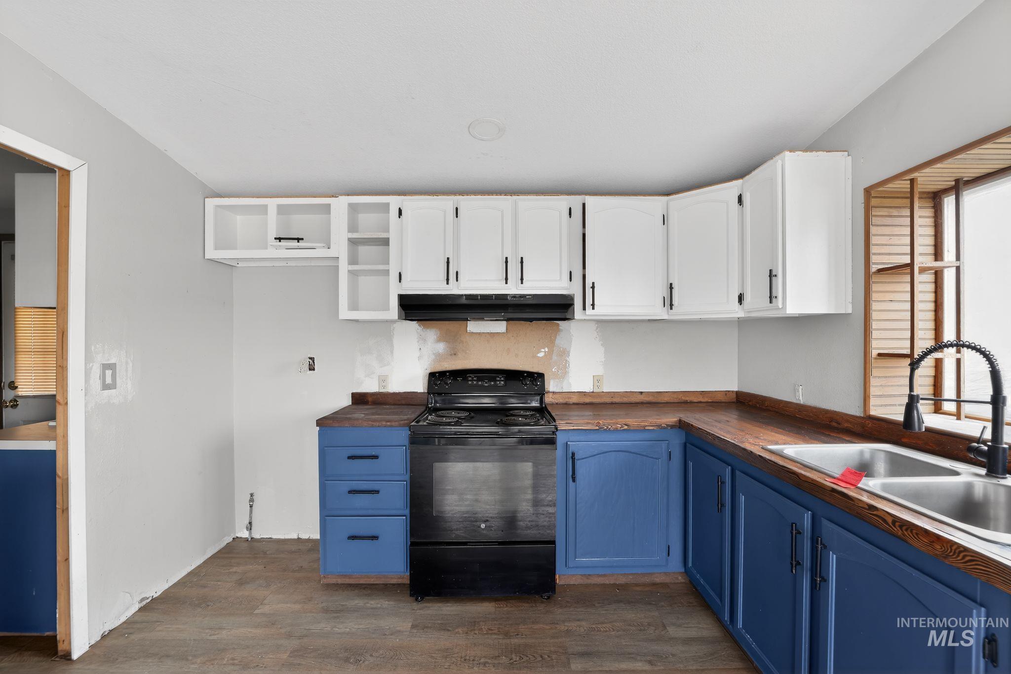 Kitchen with blue cabinetry, white cabinetry, black electric range oven, and dark wood finished floors