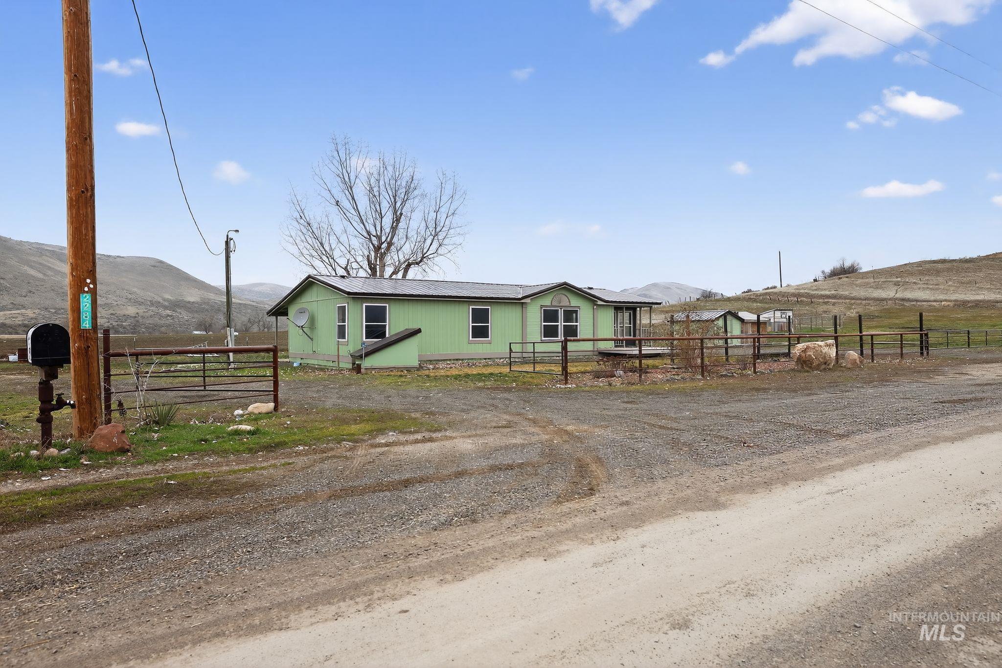 Manufactured / mobile home featuring a mountain view, a view of rural / pastoral area, and a gate