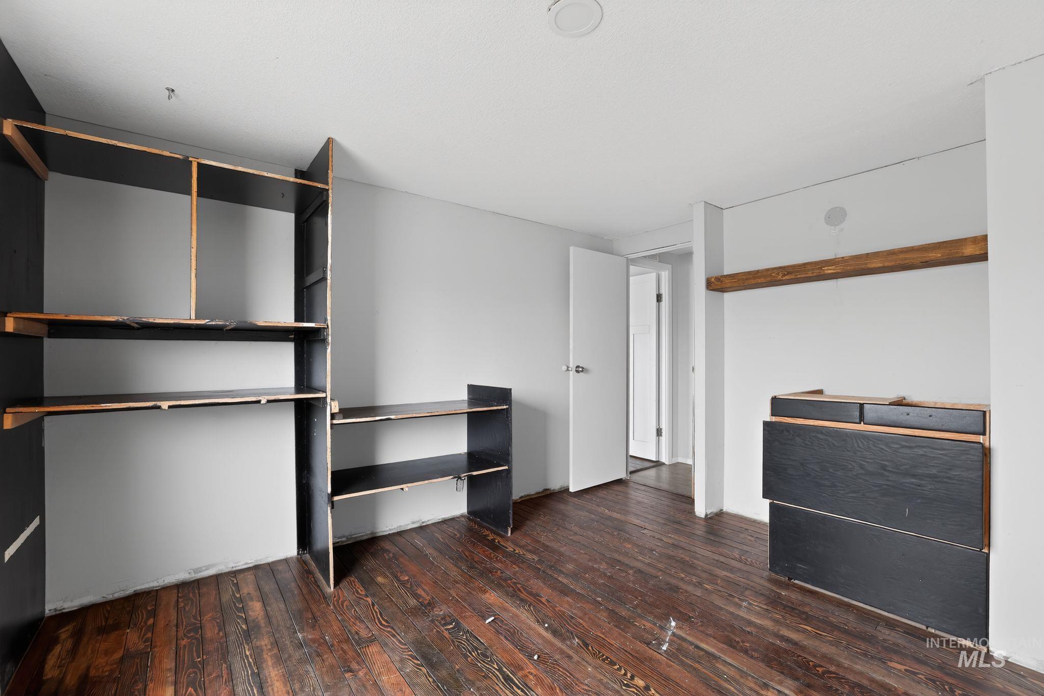 Unfurnished bedroom with dark wood-style floors