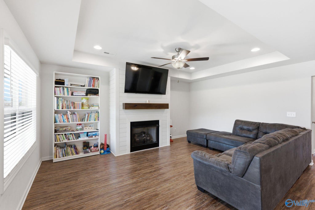 Living room with shiplap-framed fireplace and built-in shelving