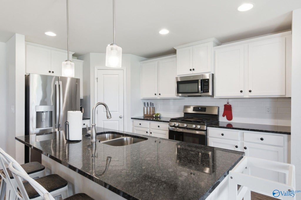 Kitchen with granite counters, large island, and stainless appliances