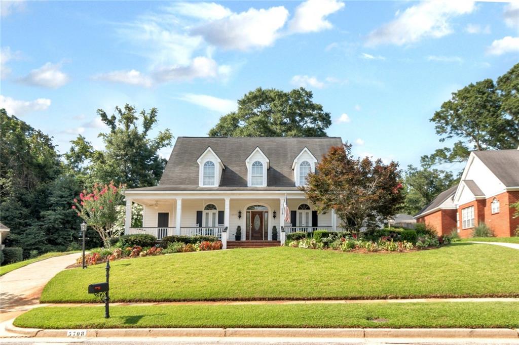 Colonial-style residence featuring a prominent covered porch with white columns