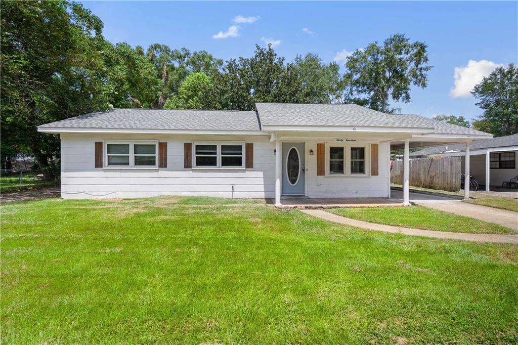 Ranch-style home featuring a porch, an attached carport, Fortified roof, and 2 concrete driveways