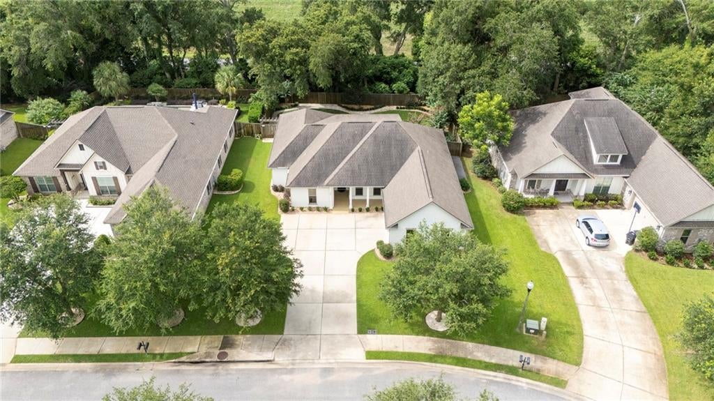 White exterior residence featuring a gray shingle roof and a spacious concrete driveway