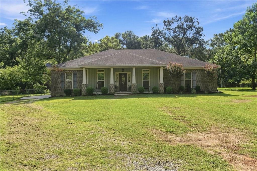 Ranch-style exterior featuring brick and siding accents, a covered front porch with white columns, and a gabled roof