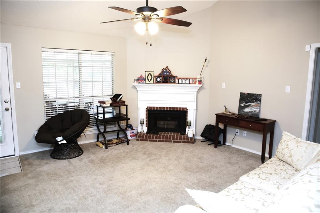 Living area Features carpet floors, Centrally located brick fireplace, and ceiling fan.