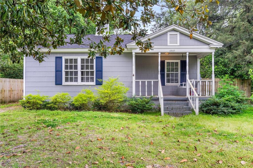 View of front of house with covered porch and a front lawn