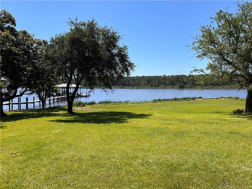 View of green lawn featuring a water view