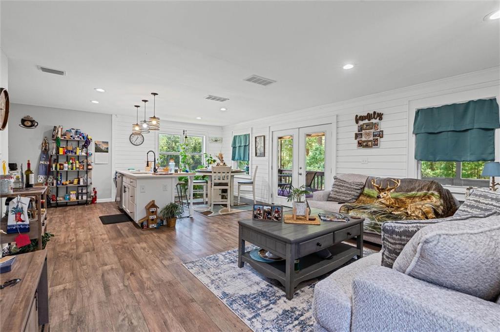 Living room featuring dark wood finished floors, recessed lighting, and french doors