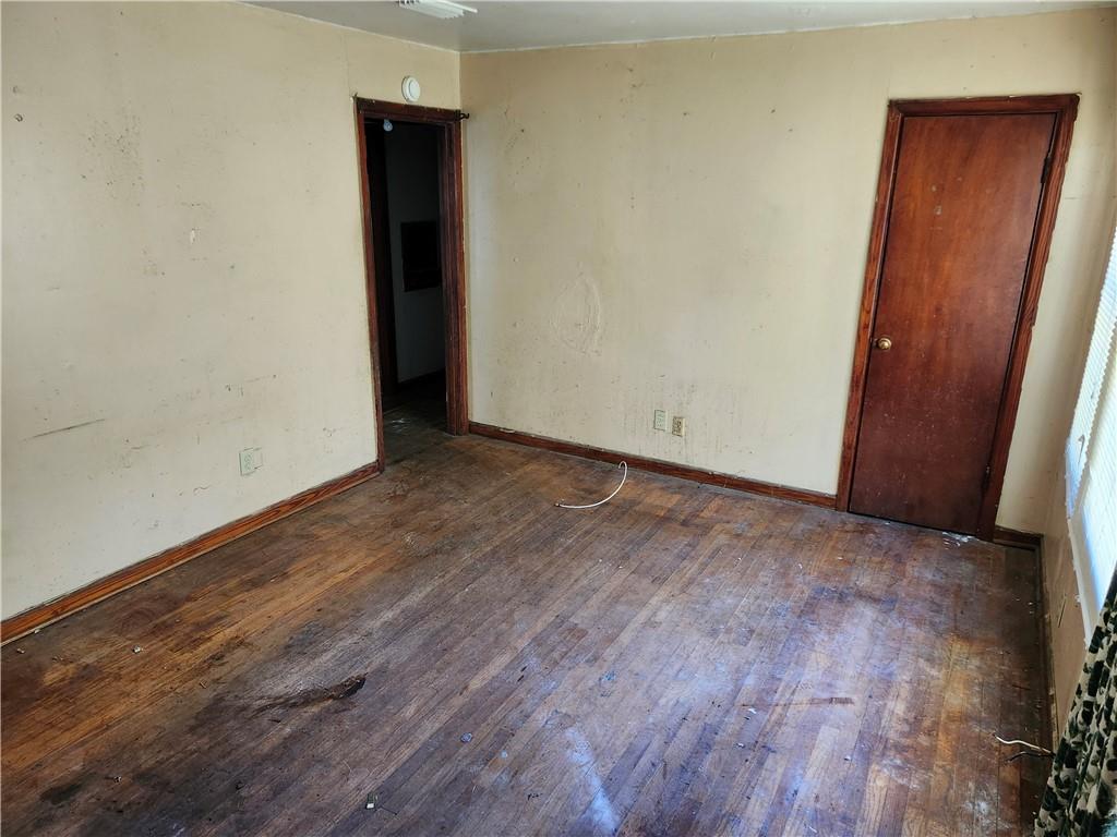 Unfurnished room featuring hardwood / wood-style floors and baseboards