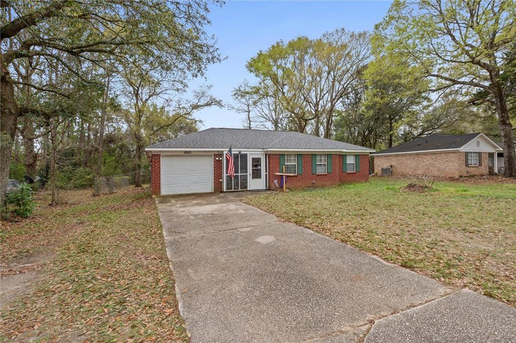 Ranch-style home featuring concrete driveway, brick siding, and an attached garage