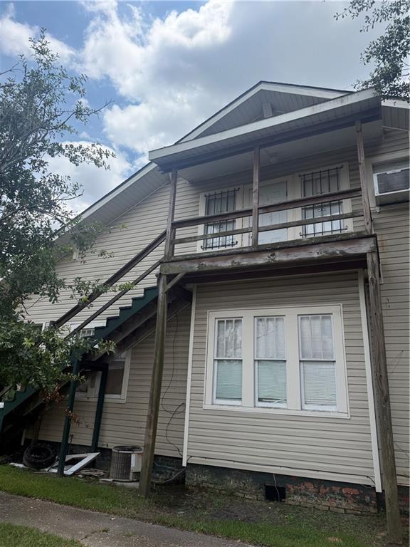 Multi-level siding exterior featuring an exterior staircase leading to a second-story balcony