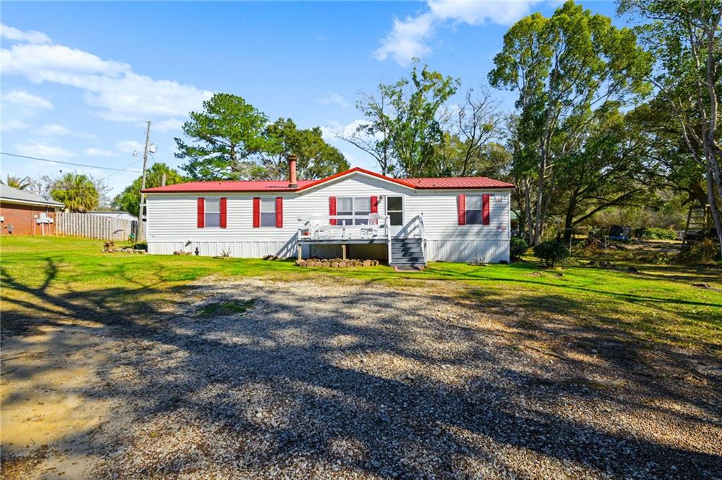 View of front facade featuring a deck and a front yard