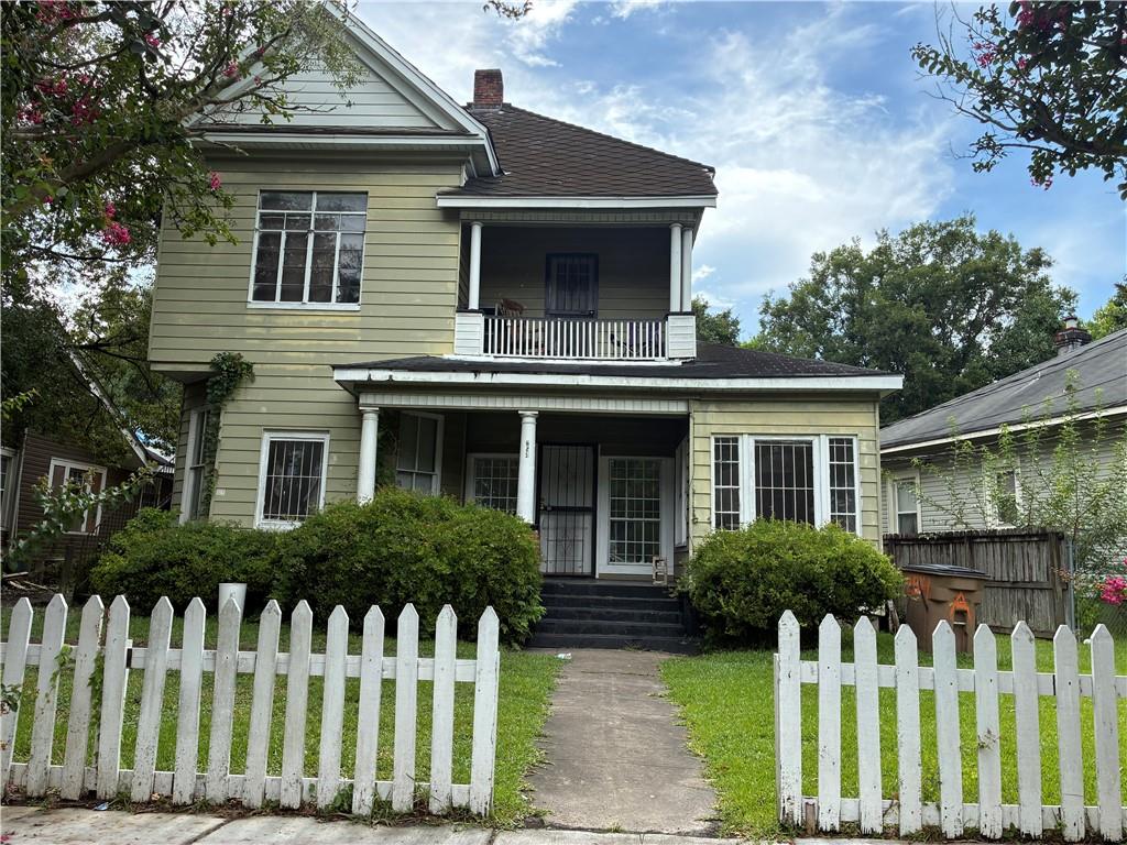 Two-story residence featuring light-colored siding and a covered front porch with white columns