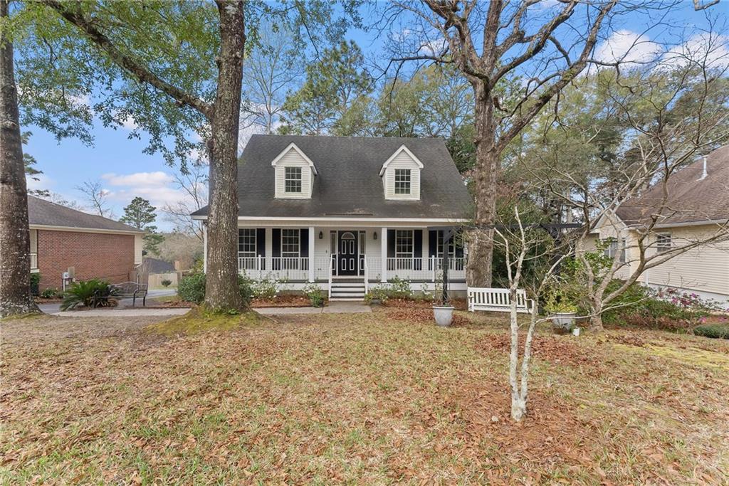 Cape cod-style house featuring a porch, a shingled roof, and a front yard