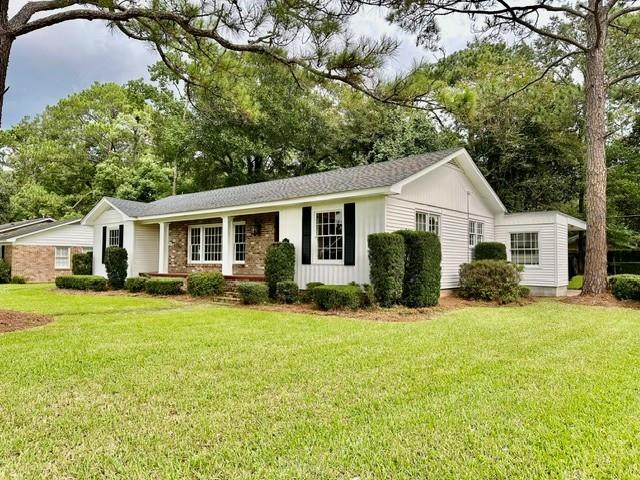 Ranch-style residence featuring a brick facade, white siding, and a covered porch