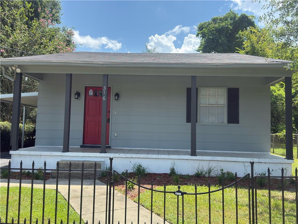 Light gray exterior with a red front door, covered porch, and dark gray support columns