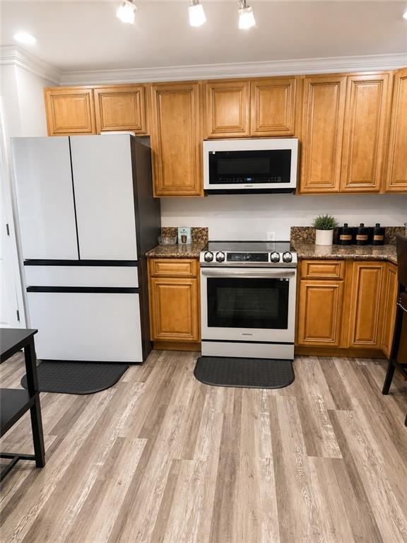 Kitchen featuring wood-finish cabinetry, stainless steel range, and stone-finish countertops